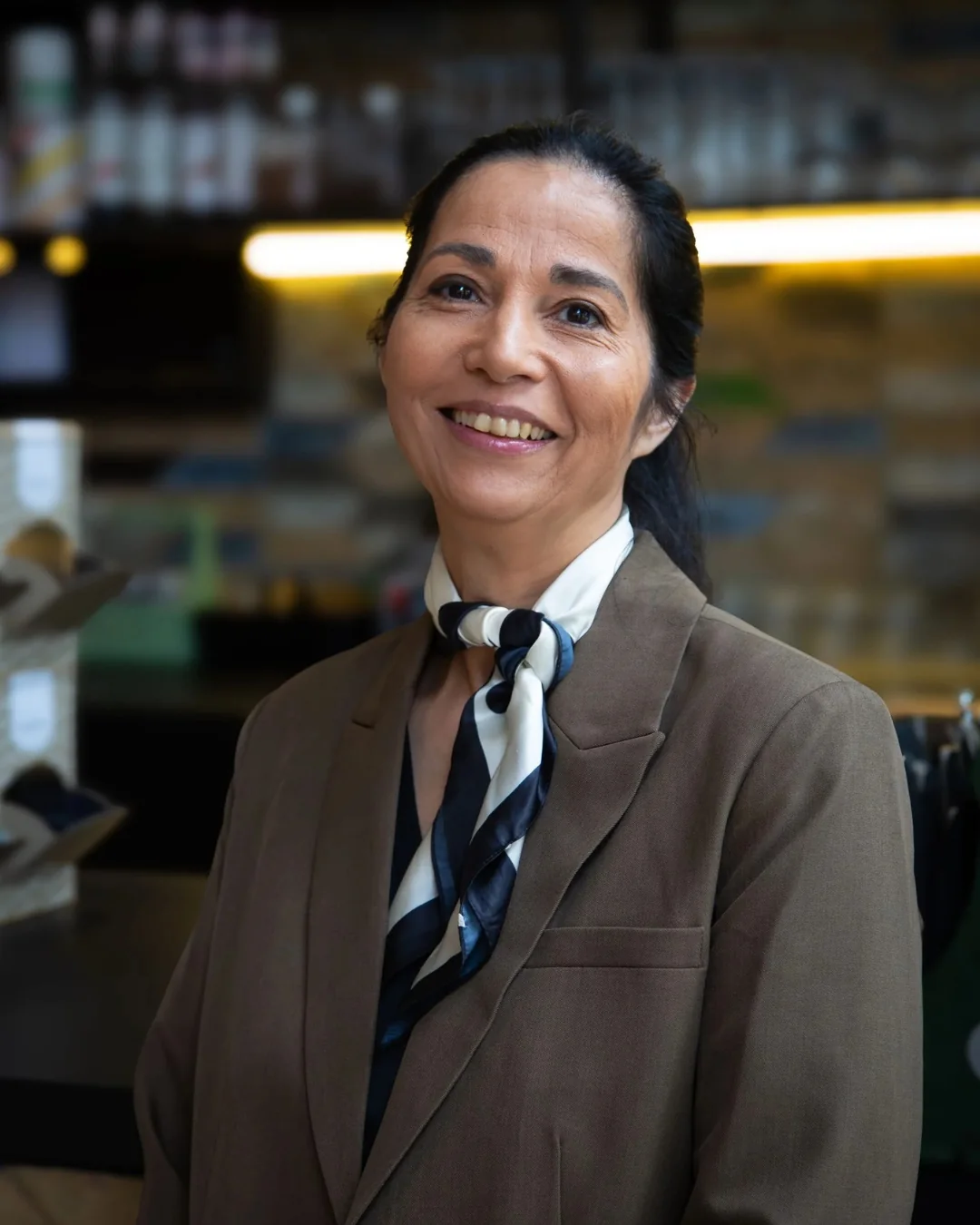 Medewerker van Blini Events lacht in een sfeervol horeca-interieur